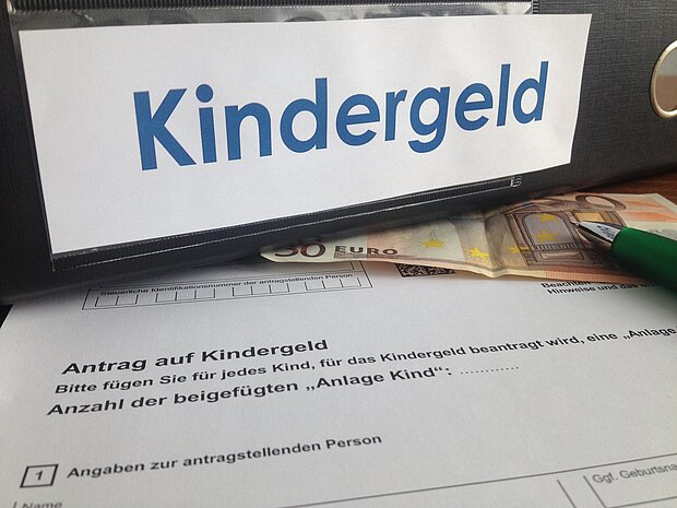 Ordner mit der Aufschrift "Kindergeld" liegt auf einem Dokument