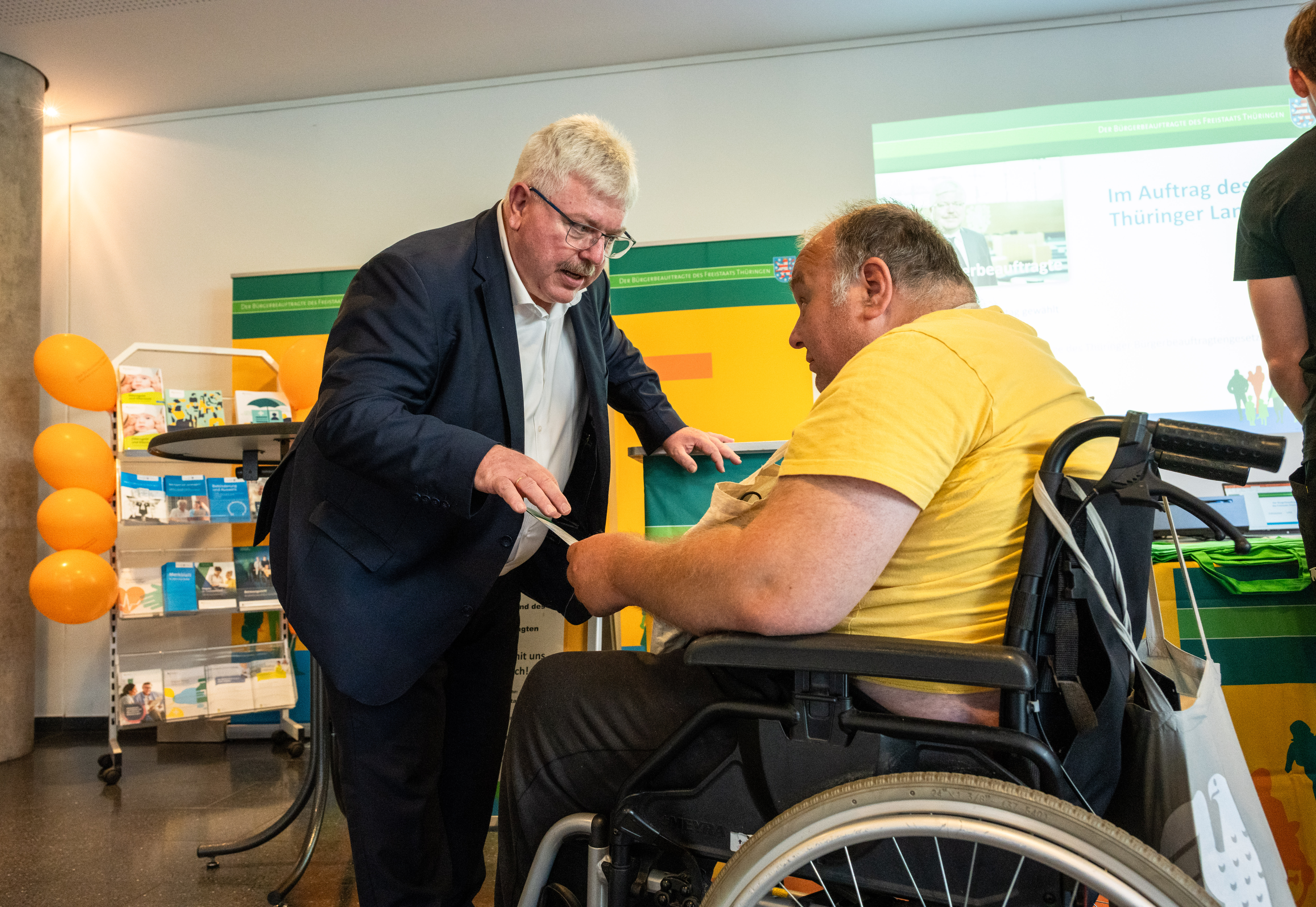 Herzberg am Infostand im Gespräch mit einem Rollstuhlfahrer 