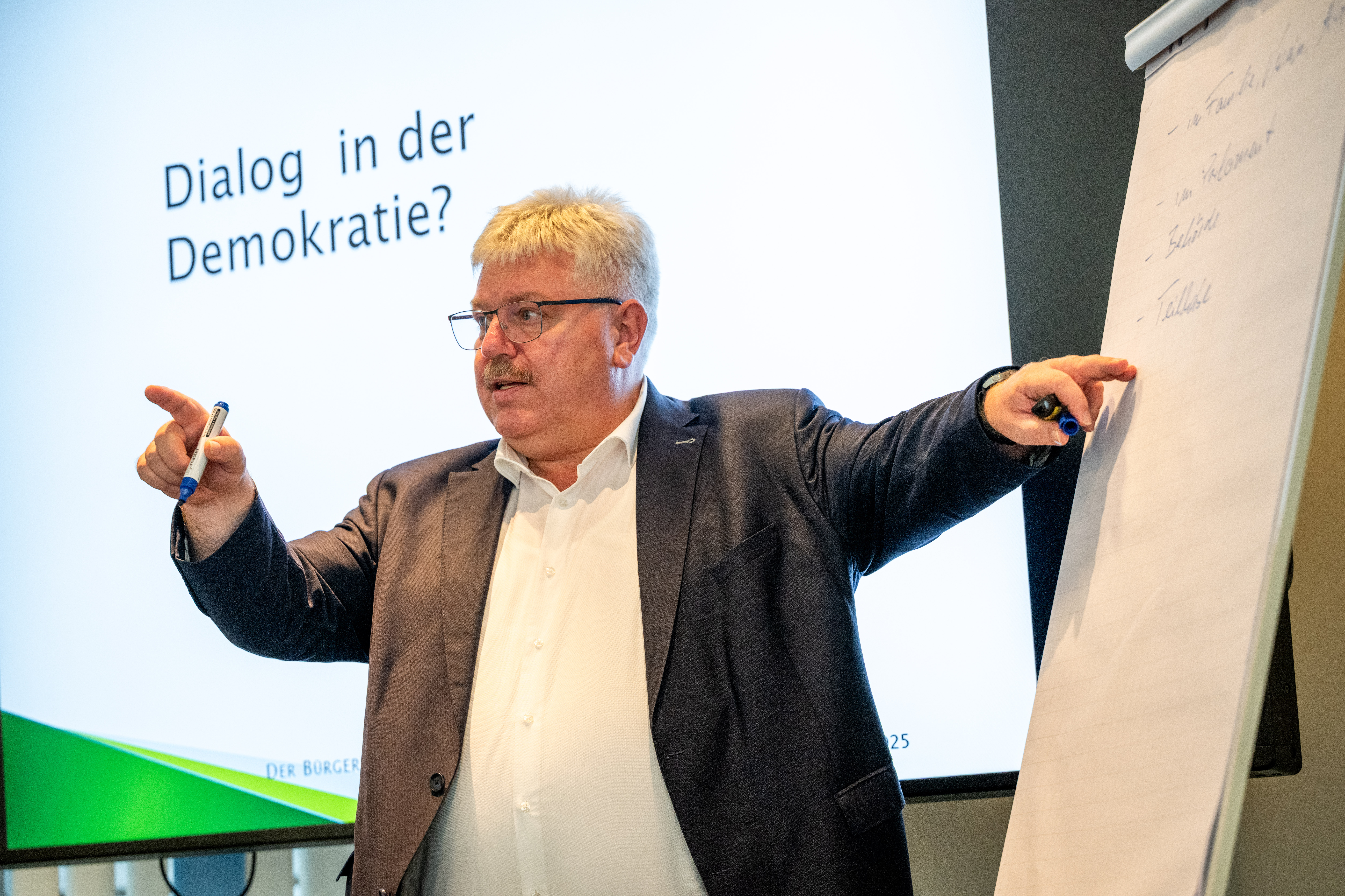 Herzberg beim Vortrag vor Bildschirm und Flipchart