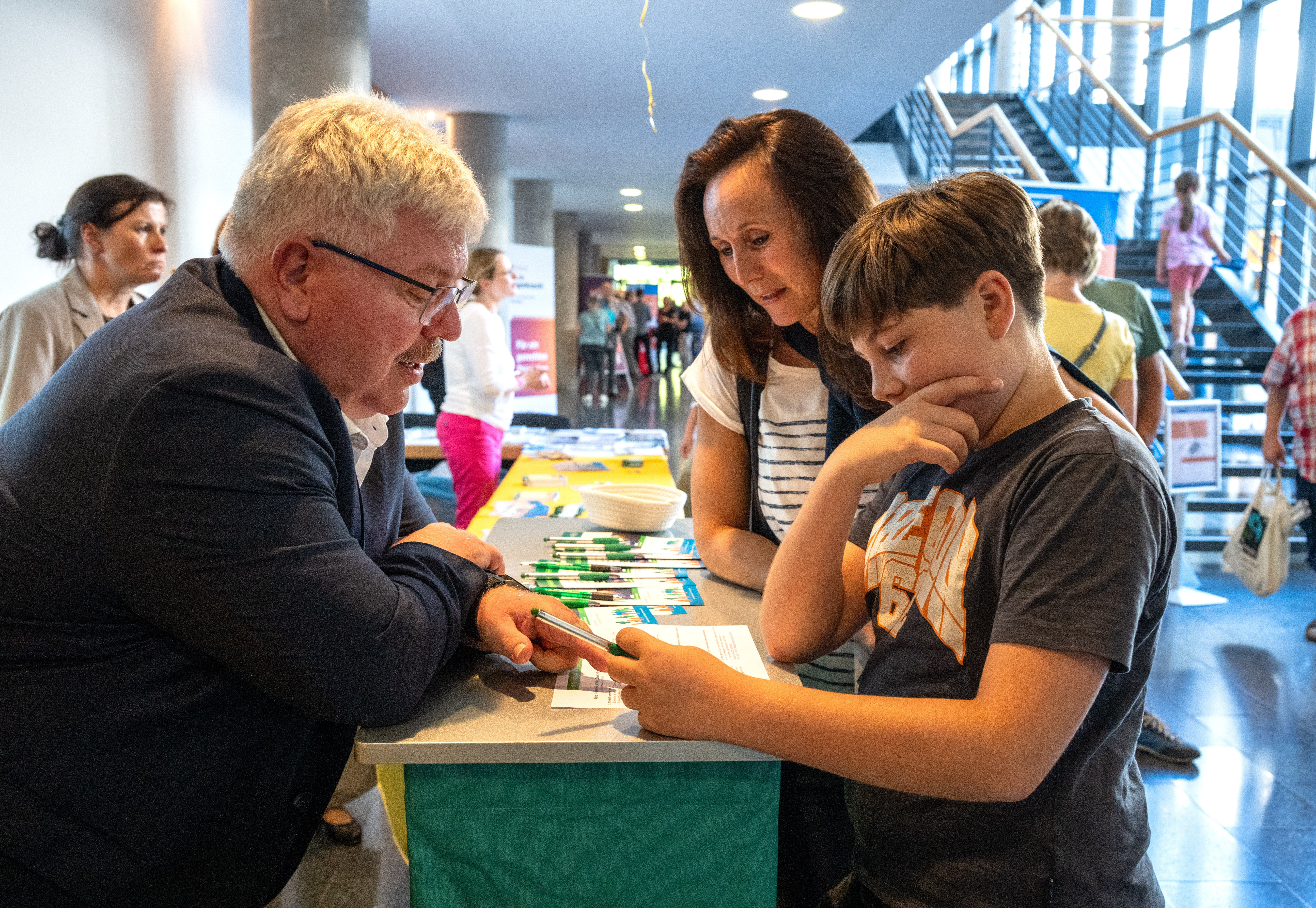 Herzberg am Infostand im Gespräch mit einer Mutter und ihrem Sohn